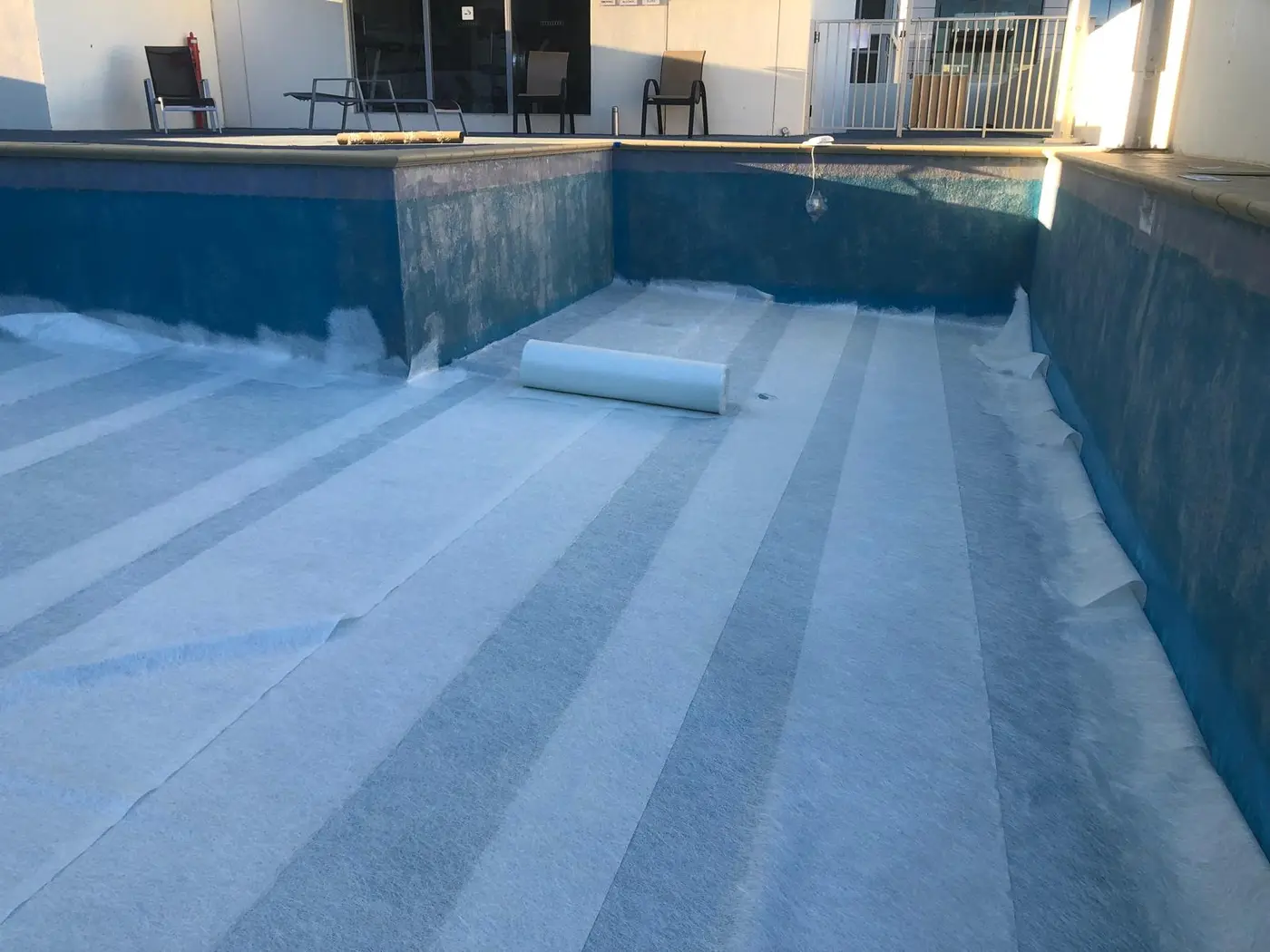 Large fibreglass pool during surface preparation for restoration