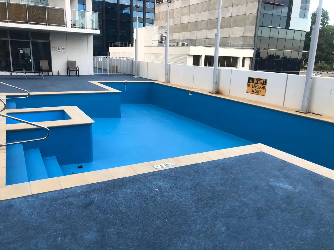 Large fibreglass pool after restoration with a renewed blue finish