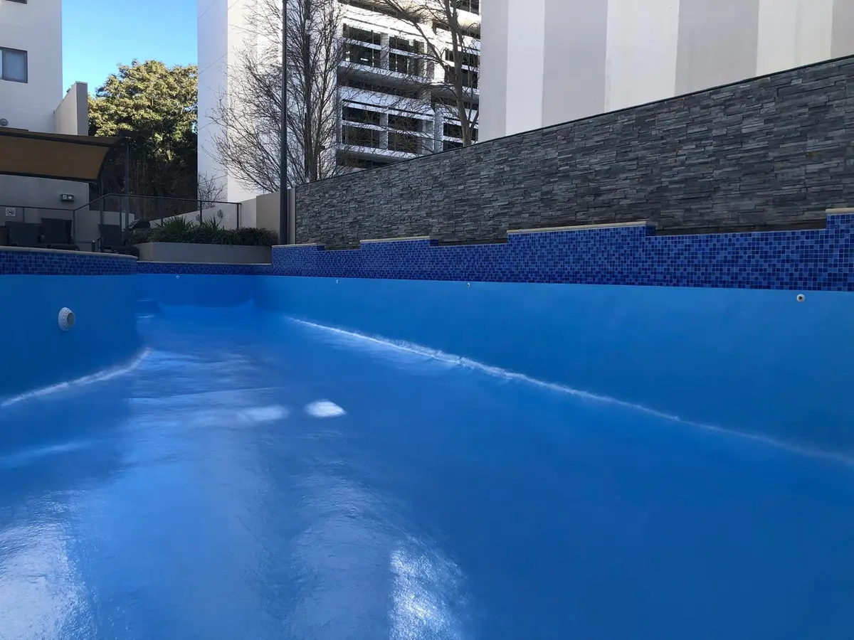 Completed fibreglass pool restoration with a smooth blue finish