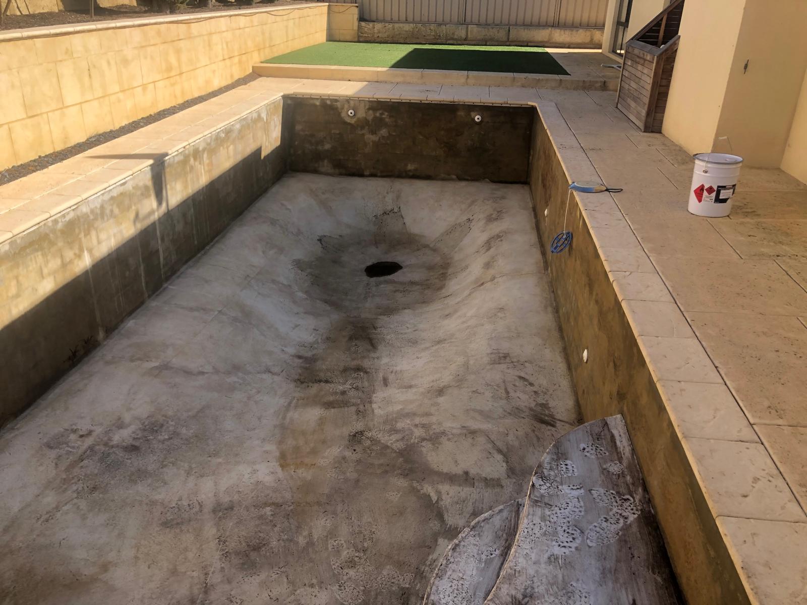 Empty rectangular swimming pool before restoration work