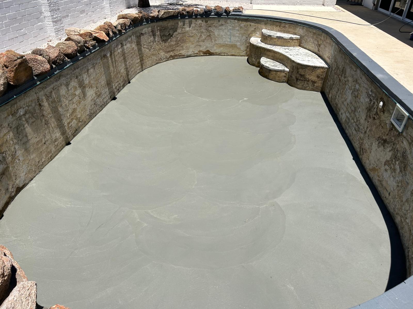Curved swimming pool during preparation for resurfacing